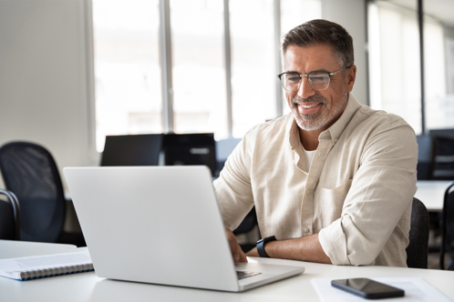 Man smiles while using his laptop