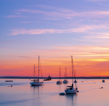 Boats on calm water at sunset