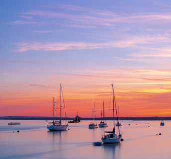 Boats on calm water at sunset